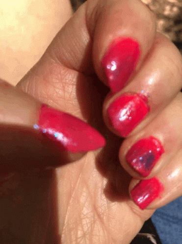 a close up of a woman 's nails with red polish on them