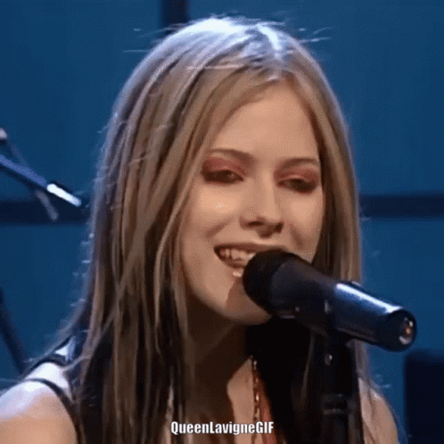 A Close Up Of A Woman Singing Into A Microphone With Queen Lavigne Gif Written On The Bottom GIF