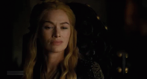 A Close Up Of A Woman Sitting In A Chair In The Dark . GIF