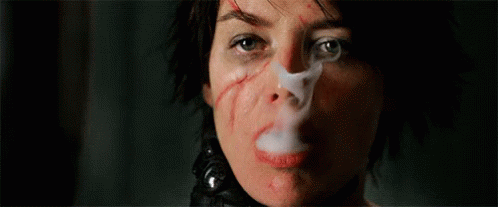 A Close Up Of A Woman Smoking A Cigarette With A Bandage On Her Face . GIF