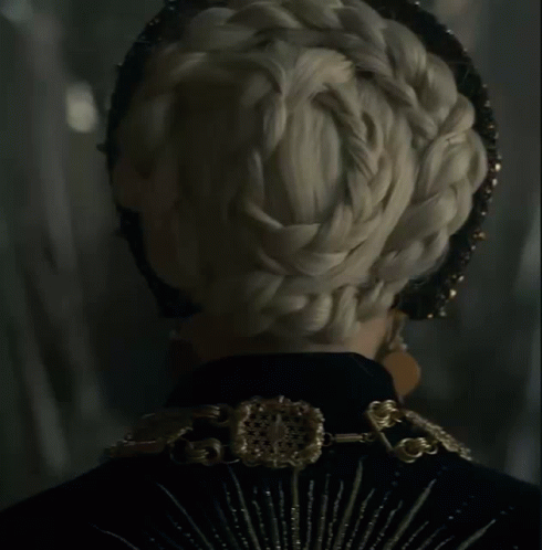 A Close Up Of A Woman Wearing A Black And Gold Outfit GIF
