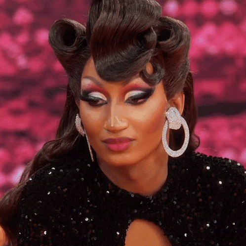 A Close Up Of A Woman Wearing A Black Dress And Earrings GIF
