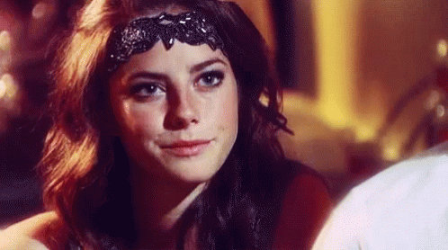 A Close Up Of A Woman Wearing A Black Headband . GIF