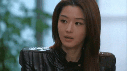 A Close Up Of A Woman Wearing A Black Leather Jacket And A Black Shirt . GIF