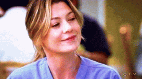 A Close Up Of A Woman Wearing A Blue Scrub Top And Smiling . GIF