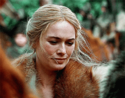 A Close Up Of A Woman Wearing A Fur Coat And Looking Down GIF