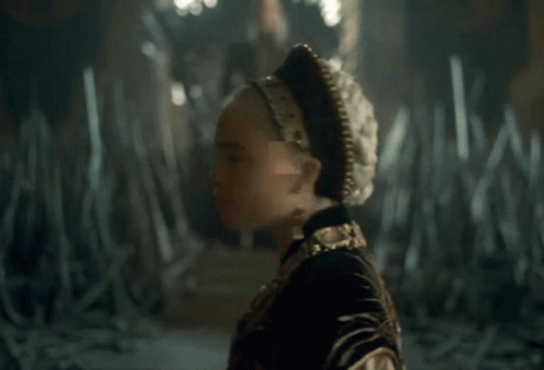 A Close Up Of A Woman Wearing A Gold Necklace And Earrings GIF