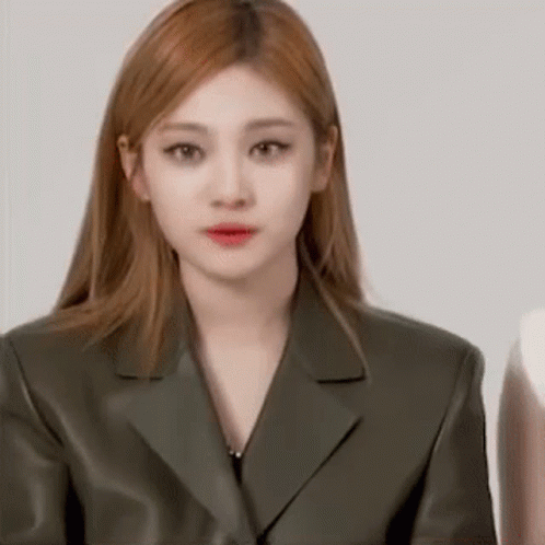 A Close Up Of A Woman Wearing A Green Suit Jacket . GIF
