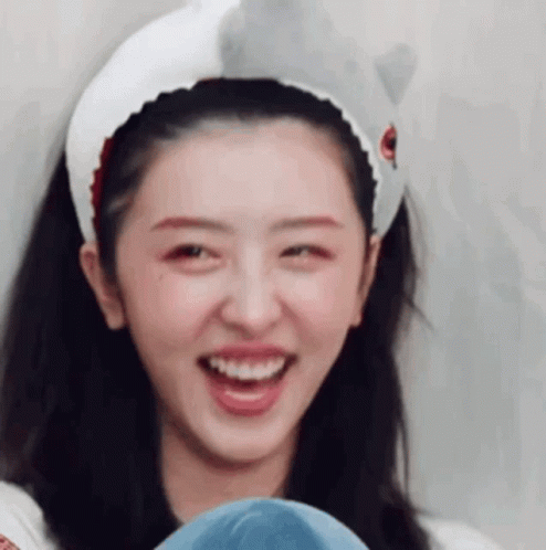 A Close Up Of A Woman Wearing A Headband With A Shark On It . GIF