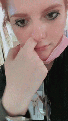 A Close Up Of A Woman Wearing A Mask And A Name Tag That Says ' Chris ' On It GIF