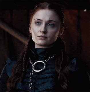 A Close Up Of A Woman Wearing A Necklace With A Chain Around Her Neck GIF
