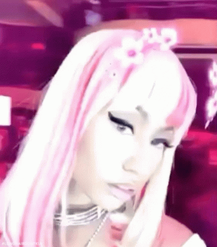 A Close Up Of A Woman Wearing A Pink And White Wig And A Flower In Her Hair . GIF