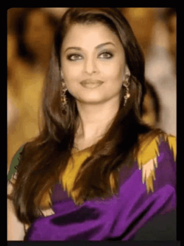 A Close Up Of A Woman Wearing A Purple And Yellow Dress GIF