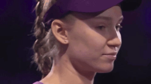 A Close Up Of A Woman Wearing A Purple Hat And A Purple Shirt GIF