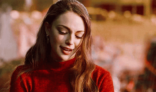 A Close Up Of A Woman Wearing A Red Sweater And Smiling . GIF