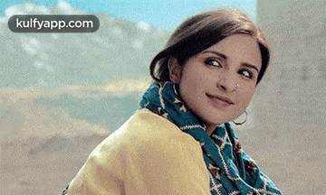 A Close Up Of A Woman Wearing A Scarf And A Yellow Jacket . GIF