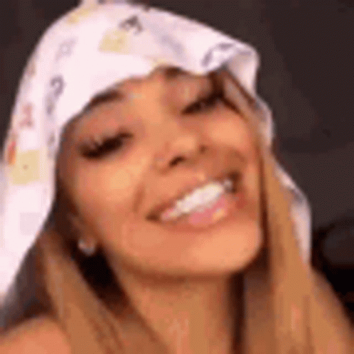 A Close Up Of A Woman Wearing A Scarf On Her Head And Smiling . GIF