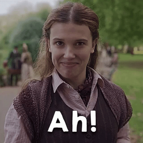 A Close Up Of A Woman Wearing A Vest And Smiling With The Words Ah ! GIF