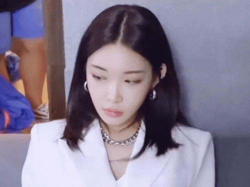 A Close Up Of A Woman Wearing A White Jacket And A Silver Necklace GIF