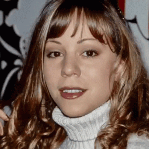 A Close Up Of A Woman Wearing A White Turtleneck GIF