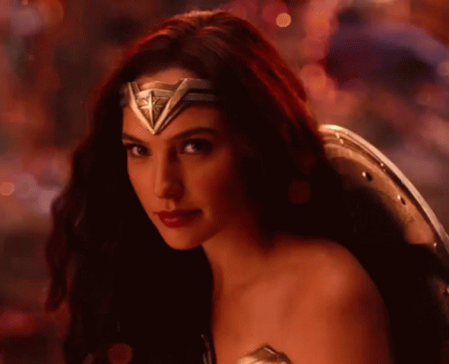 A Close Up Of A Woman Wearing A Wonder Woman Costume And Shield . GIF