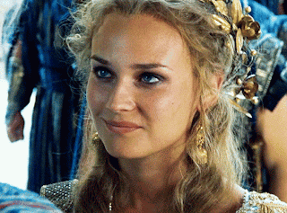 A Close Up Of A Woman Wearing A Wreath Of Gold Leaves In Her Hair GIF