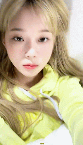 A Close Up Of A Woman Wearing A Yellow Hoodie . GIF