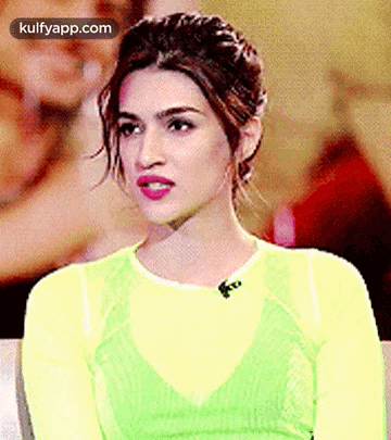 A Close Up Of A Woman Wearing A Yellow Top And A Green Top . GIF