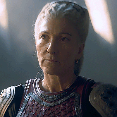 A Close Up Of A Woman Wearing Armor With A Serious Look On Her Face GIF