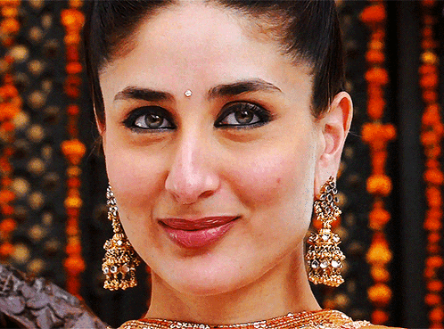 A Close Up Of A Woman Wearing Earrings And A Bindi GIF