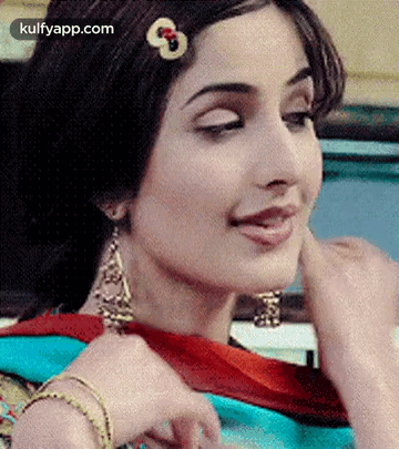 A Close Up Of A Woman Wearing Earrings And A Hair Clip . GIF