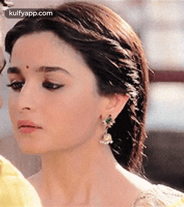 A Close Up Of A Woman Wearing Earrings And A Headband . GIF