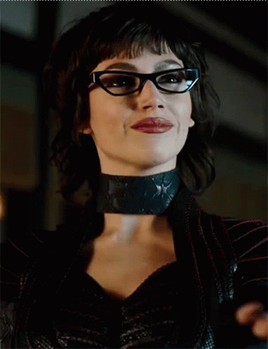 A Close Up Of A Woman Wearing Glasses And A Black Choker GIF