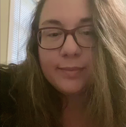 A Close Up Of A Woman Wearing Glasses And Smiling At The Camera . GIF