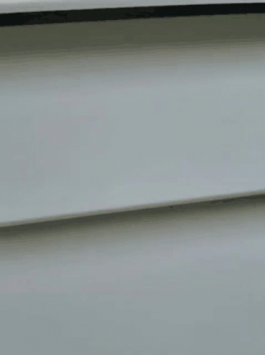 A Close Up Of A Woman Wearing Glasses Looking Out Of A Window GIF