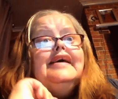 A Close Up Of A Woman Wearing Glasses Making A Face GIF