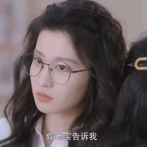 A Close Up Of A Woman Wearing Glasses With Chinese Writing GIF