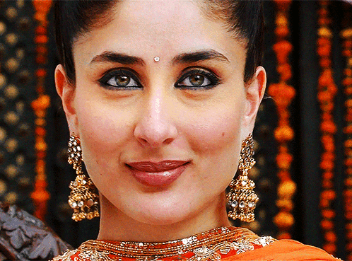 A Close Up Of A Woman Wearing Gold Earrings GIF