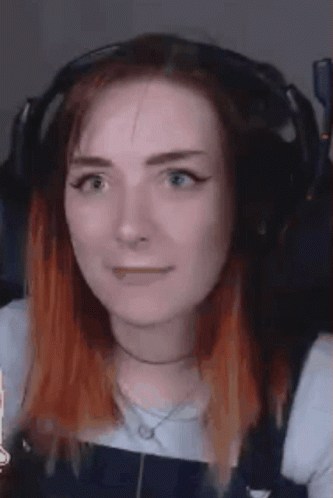 A Close Up Of A Woman Wearing Headphones And Making A Face . GIF