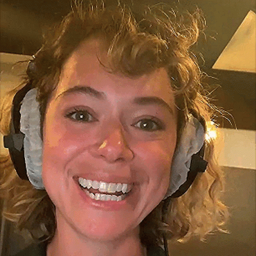 A Close Up Of A Woman Wearing Headphones Smiling GIF