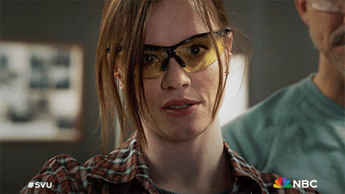 A Close Up Of A Woman Wearing Safety Glasses With A Nbc Logo In The Background GIF