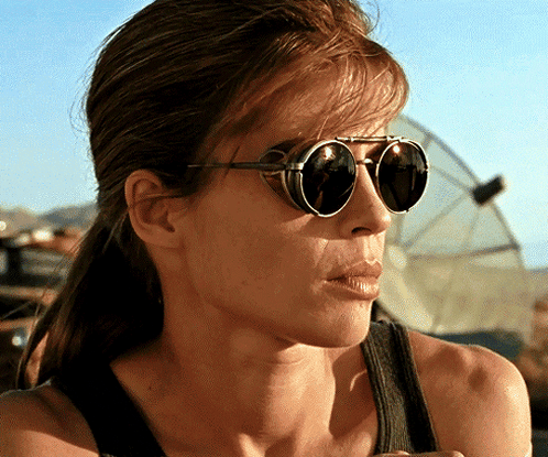 a close up of a woman wearing sunglasses and a black tank top