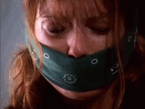 a close up of a woman with a bandana around her mouth .