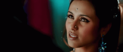 A Close Up Of A Woman With A Nose Ring And Earrings GIF