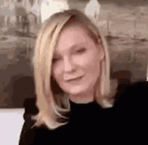 A Close Up Of A Woman With Blonde Hair Wearing A Black Shirt . GIF
