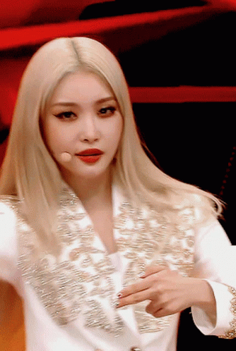 A Close Up Of A Woman With Blonde Hair Wearing A White Jacket GIF