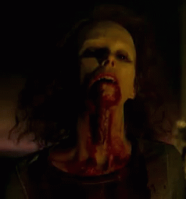 a close up of a woman with blood on her face and mouth .