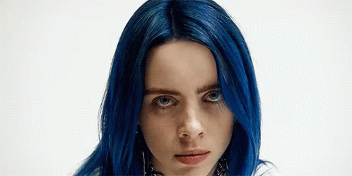 A Close Up Of A Woman With Blue Hair And Blue Eyes . GIF