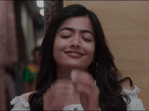 A Close Up Of A Woman With Her Eyes Closed And Her Hands Folded . GIF