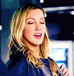 A Close Up Of A Woman With Her Eyes Closed Wearing A Blue Jacket . GIF